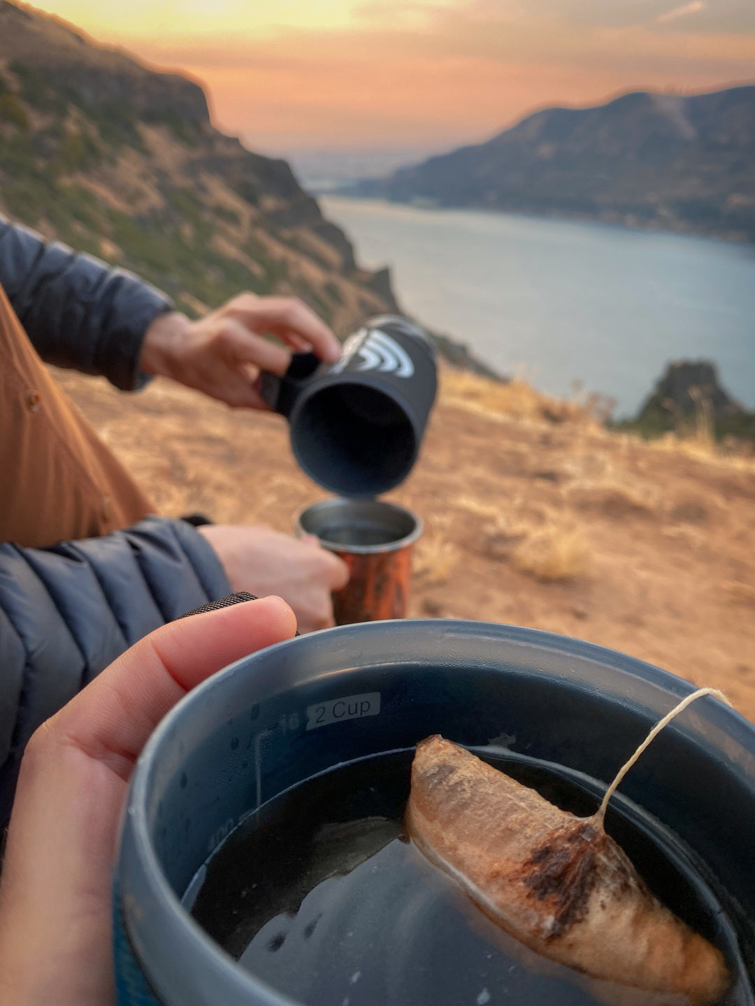 Wildland Coffee bag in cup overlooking lake at sunrise. My friend and I took two of these up a mountain for sunrise and were really worried it wouldn't be "coffee" enough just being steeped. It was perfect. So much easier than carrying a french press!